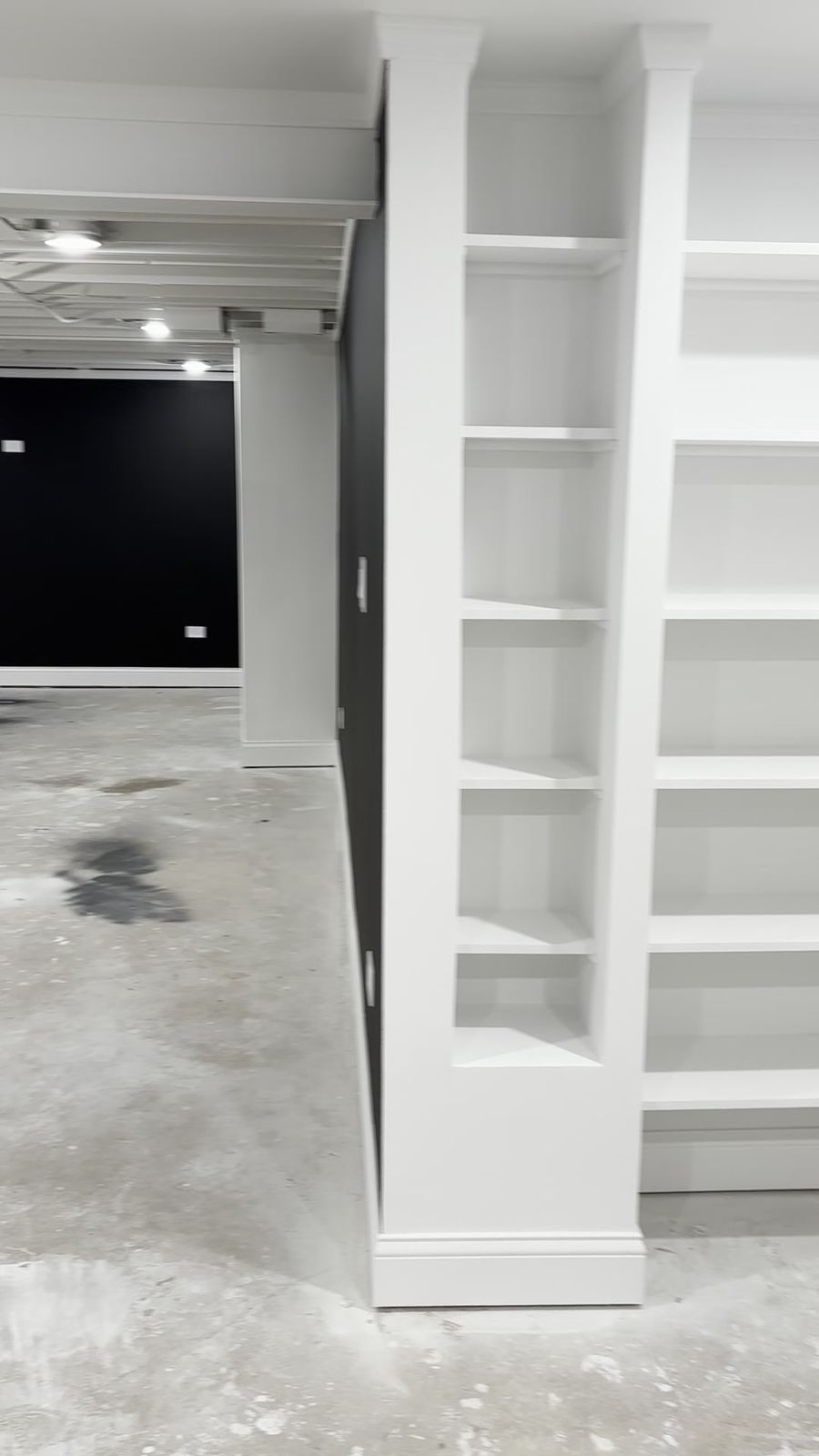 Finished wall with custom white built-in shelving