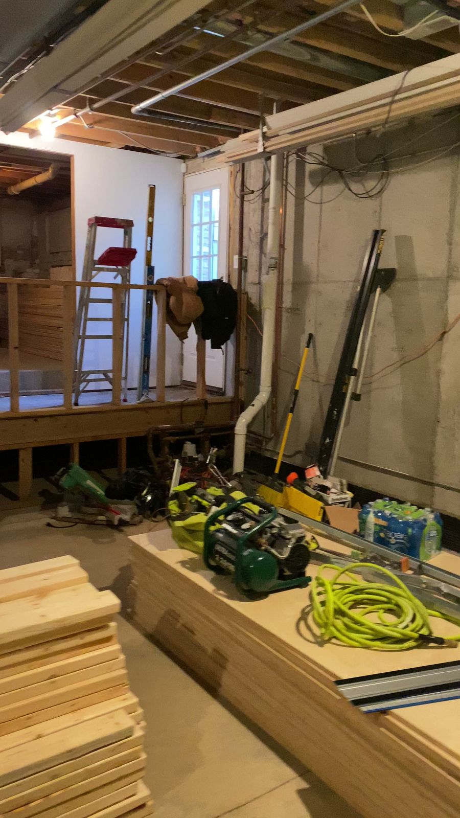 Unfinished basement with open framing and construction materials