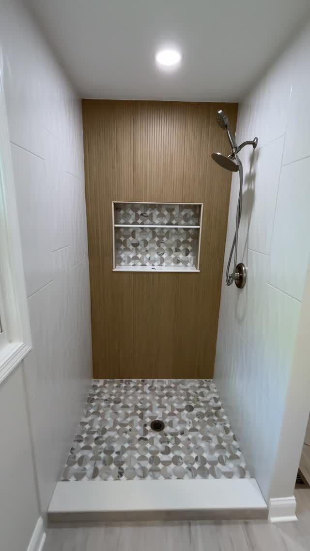 Wood-look shower wall with pebble floor