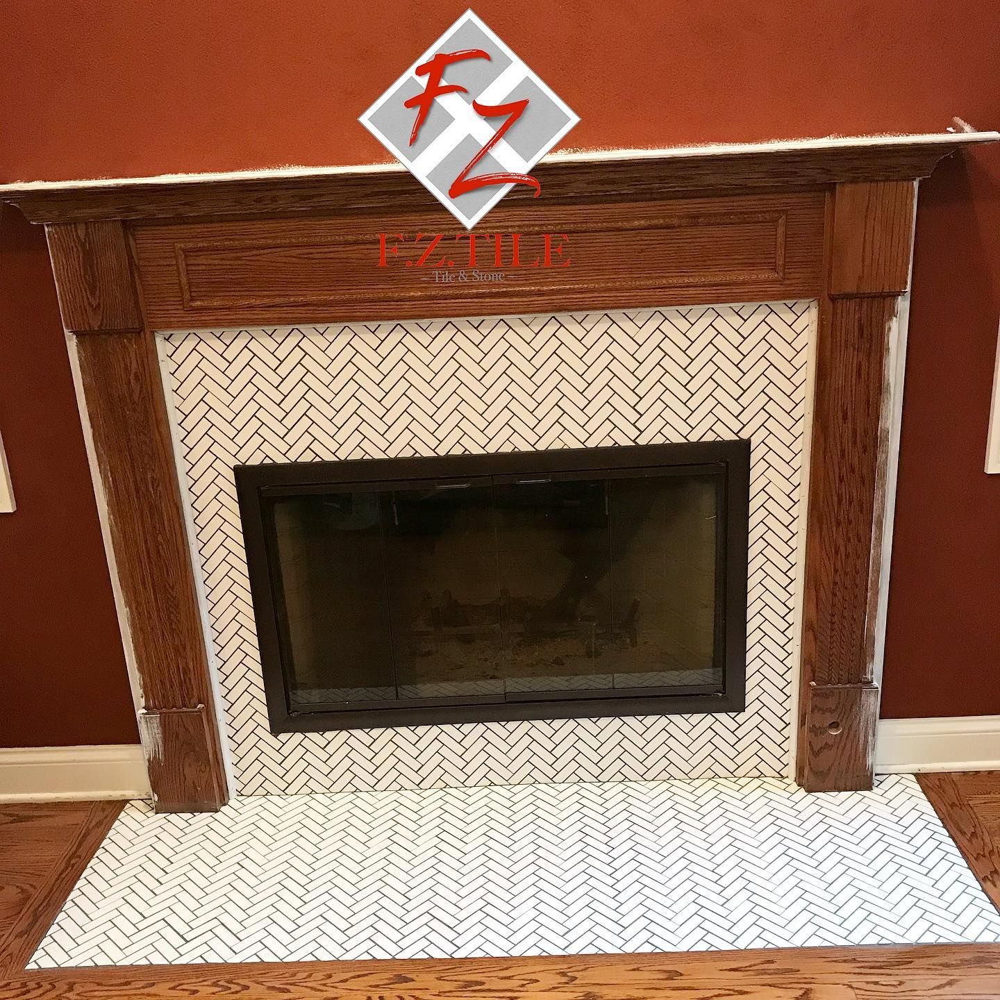 Herringbone tile fireplace surround with a wood mantel