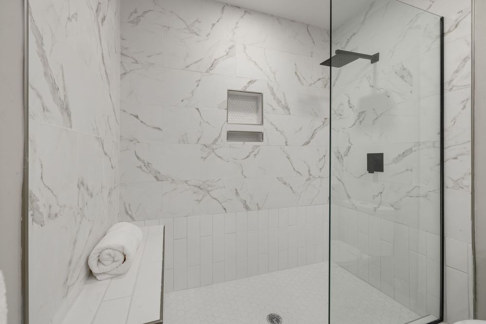 White marble walk-in shower with glass door